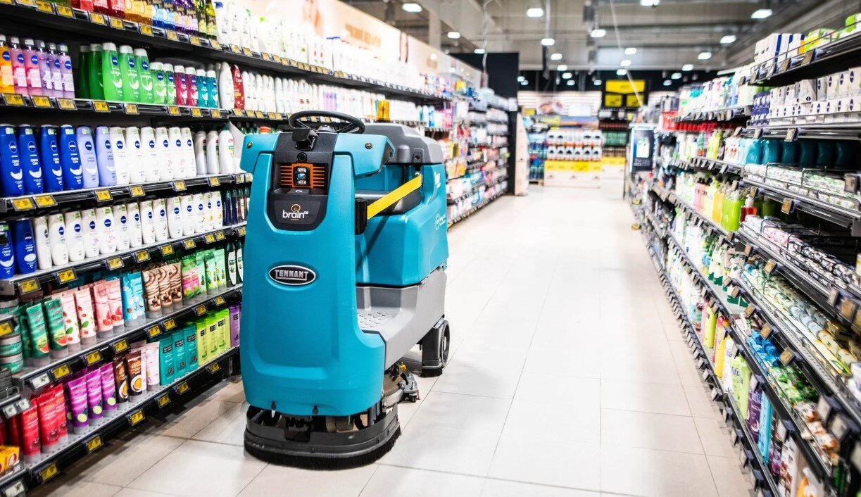 A Brain Corp autonomous cleaning robot scrubbing a retail store aisle